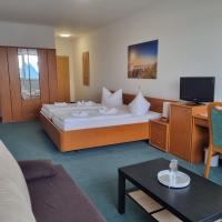 a hotel room with a large bed and a tv at Müritz-Pension Waren in Waren