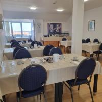 a dining room with tables and chairs in a room at Müritz-Pension Waren in Waren