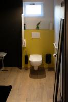 a bathroom with a toilet with a yellow wall at Vakantieverblijf De Backstage in Heuvelland
