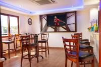 a bar with wooden chairs and a tv on the wall at West Lerruat Hotel in Nairobi