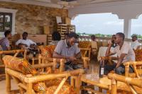 塔马拉Ruk's Hotel的坐在餐馆桌子上的一群男人