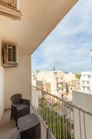 a balcony with chairs and a view of buildings at Brand new 1BR in central MALTA-Hosted by Sweetstay in Tal-Pietà