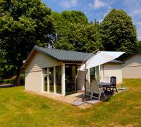 una casa con mesa y sombrilla en Vakantie Zuid Limburg, en Simpelveld