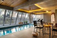 a house with a swimming pool with chairs and a table at Jangal das Araucárias Swan Design Hotel Canela in Canela
