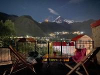 balcón con mesa y vistas a la montaña en Four Season In Kazbegi, en Kazbegi