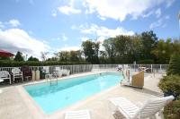 una piscina con sillas blancas y una valla en Motel 6-Colchester, VT - Burlington, en Burlington