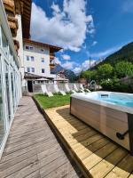 a hot tub on a deck next to a building at Hotel Astoria in Canazei