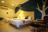 a bedroom with two beds with a tree painted on the wall at Yudo B&amp;B Yilan in Dongshan