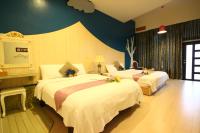 a bedroom with two beds and a blue wall at Yudo B&amp;B Yilan in Dongshan
