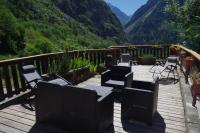 eine Terrasse mit Stühlen und Tischen sowie Bergblick in der Unterkunft Chalet les Alpes - Le Sapey in Vénosc