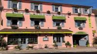 a pink building with green accents on a street at Hotel de Bourgogne in Saulieu