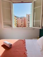a bed in a room with a large window at Appartement Bonaparte centre ville d&#39;Ajaccio in Ajaccio