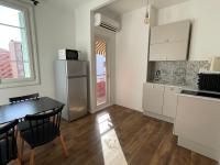 a kitchen with a table and a refrigerator at Appartement Bonaparte centre ville d&#39;Ajaccio in Ajaccio