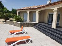 two orange chairs on a patio in front of a house at villa 15 personnes avec piscine et terrain de pétanque in Puysserampion