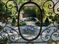 a garden through a gate with a table and chairs at Villa Amara in Aix-en-Provence