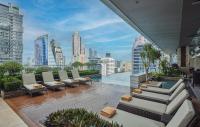 a balcony with couches and a view of a city at Eastin Grand Hotel Sathorn in Bangkok