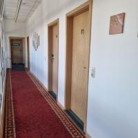 a hallway with doors and a red carpet at Müritz-Pension Waren in Waren