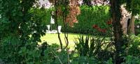 a garden with a white chair sitting in the grass at Les Clés du Parc in Combrand