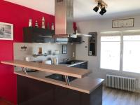 a kitchen with red walls and a wooden counter top at La Maison des phares in Lion-sur-Mer