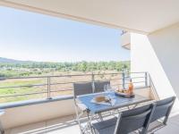 a table and chairs on a balcony with a view at Apartment Stanatura-4 by Interhome in Porto-Vecchio