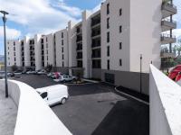 a parking lot with a white car parked in front of a building at Apartment Stanatura-4 by Interhome in Porto-Vecchio