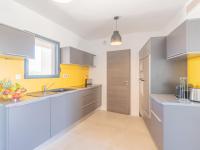 a kitchen with yellow and white cabinets and a sink at Apartment Stanatura-4 by Interhome in Porto-Vecchio