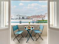 a table and chairs on a balcony with a view of a ship at Studio La Pergola-8 by Interhome in Saint-Jean-de-Luz