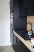 - une cuisine avec des placards noirs et un évier dans l&#39;établissement Elgebar YourHostHelper, à Caen