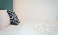 a black and white pillow sitting on a bed at Bethlehem B&amp;B Kenting in Eluan