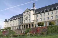 a large white building with a black roof at Kardinal Schulte Haus in Bergisch Gladbach