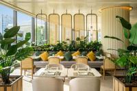 Un restaurante con mesas, sillas y plantas. en The Fullerton Ocean Park Hotel Hong Kong, en Hong Kong