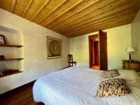 a bedroom with a white bed and a wooden ceiling at Chalet Altus in Sainte-Foy-Tarentaise