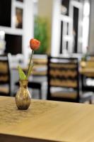 un jarrón con una flor en una mesa en Kurhotel Grüttner mit eigenem Sole Thermal Schwimmbad 32 Grad und Saunalandschaft, en Erwitte