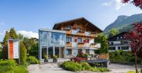a house in the mountains with a glass facade at Haus Bergblick in Fuschl am See