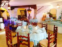 a dining room with tables and chairs with white table cloth at Hotel Cala di Mola in Porto Azzurro
