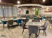 ein Restaurant mit Tischen und Stühlen in einem Raum in der Unterkunft Fumani Game Lodge in Modimolle