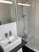 a white bathroom with a sink and a shower at Les Pastels in La Roche-sur-Yon