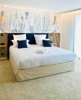 a bedroom with a large white bed with blue pillows at EDEN HÔTEL in Sainte-Maxime