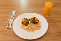 Um prato de comida com batatas e arroz e um copo de suco de laranja. em Paradiso Corporate em Cabo Frio