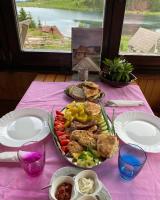 a table with a plate of food on a pink table cloth at Zlatna koliba Namir Zuka in Fojnica