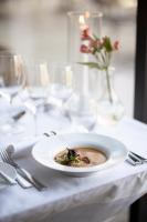 a white plate of food on a table with a table cloth at Gränsö Slott Hotel & Spa in Västervik