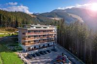 an aerial view of a hotel with cars parked in a parking lot at Hotel Strachan Family Jasná in Demanovska Dolina
