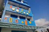 a blue building with clocks on the side of it at Country Kos Hostel in Kenting