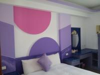 a purple and white bedroom with a bed and a mirror at Country Kos Hostel in Kenting
