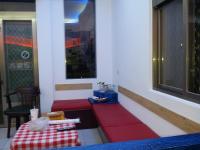 a red bench in a room with a table at Country Kos Hostel in Kenting