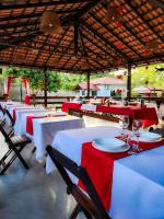 un restaurant avec des tables et des chaises rouges et blanches dans l'établissement Pousada e Restaurante Amazonia, à Alter do Chão