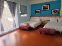 a bedroom with two beds and a teddy bear sitting between them at 草莓牛奶台東民宿可洽包棟 in Taitung City