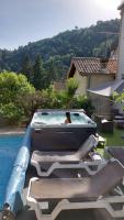 a woman in a swimming pool next to a house at Pavillon Kalensa in Vals-les-Bains