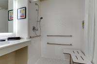 a white bathroom with a shower and a sink at Holiday Inn Mobile Airport by IHG in Mobile
