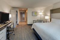 a hotel room with a bed and a flat screen tv at Holiday Inn Mobile Airport by IHG in Mobile